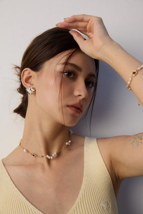 Woman wearing a necklace and earrings with a neutral background