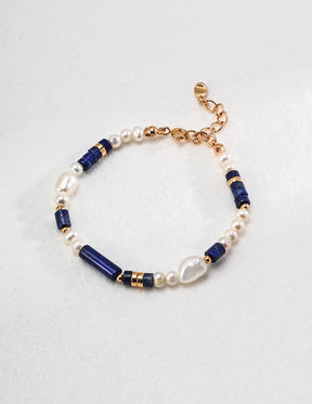Bracelet with blue and gold beads on a light gray background