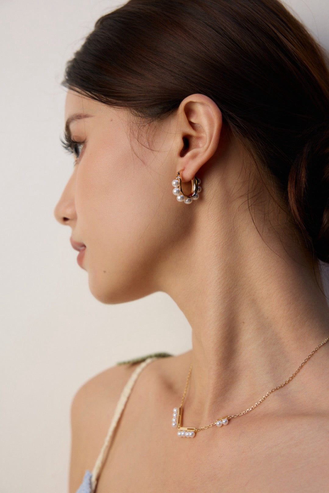 Pearl gold hoop earrings and a delicate pearl necklace for women.