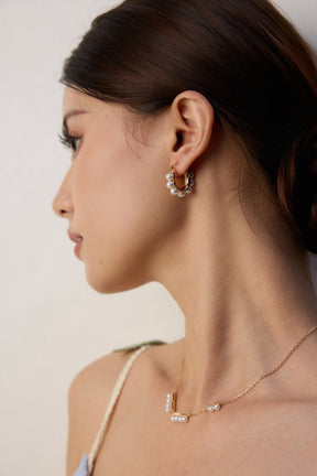 Pearl gold hoop earrings and a delicate pearl necklace for women.
