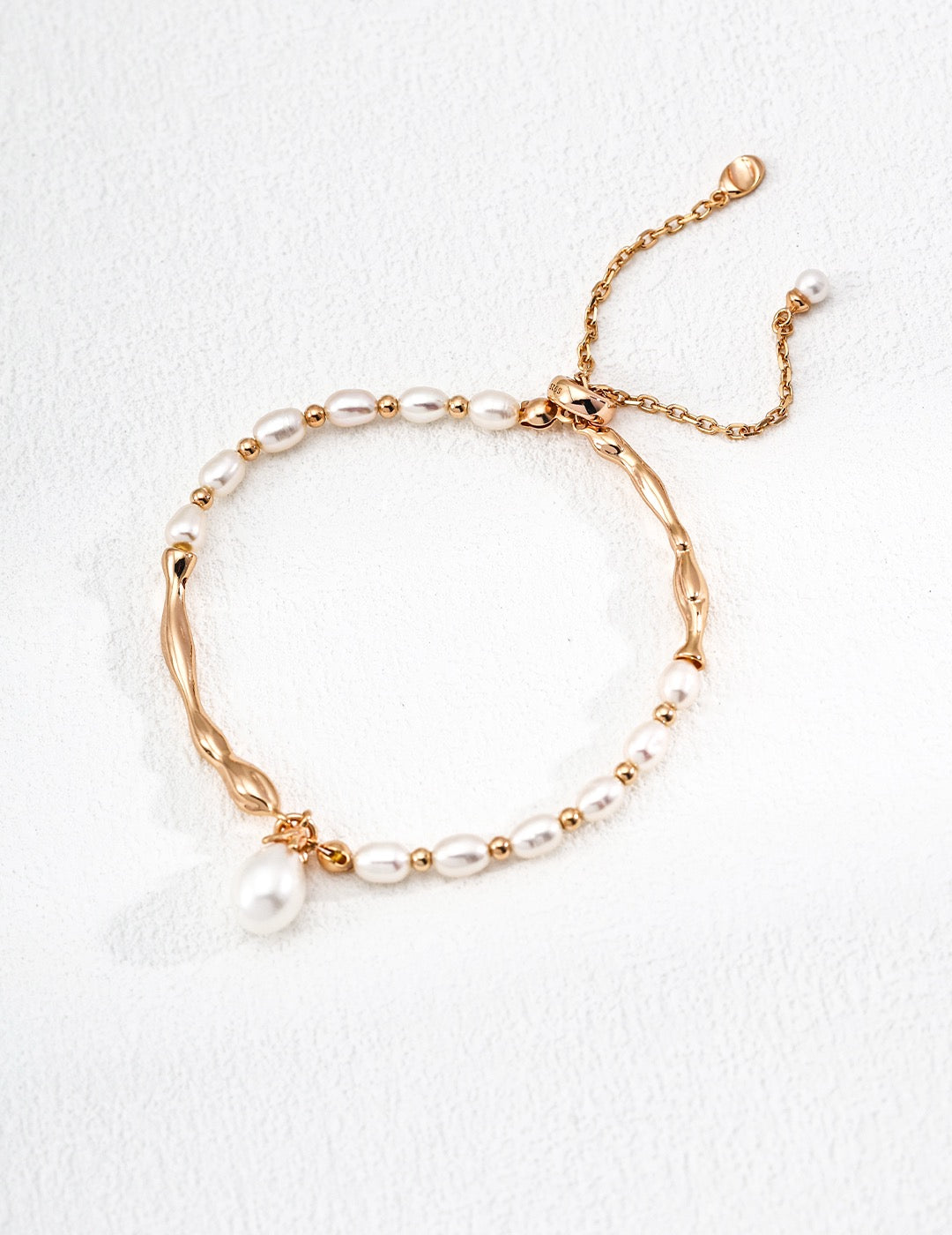 Celestial Harmony Pearl Bracelet with mixed freshwater pearls & 18k gold vermeil waves displayed on the white background.