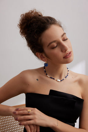 Woman wearing a black strapless dress with a white background, style with Celestial Shoreline Necklace and Indigo Moon Drop Earrings 