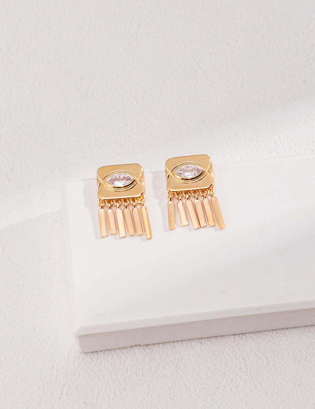 Inez Zircon Tassels Earrings displayed on the white rock.