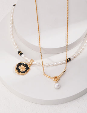 Two necklaces with pendants on a white surface