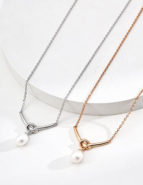 Two necklaces with pearl pendants on a white background