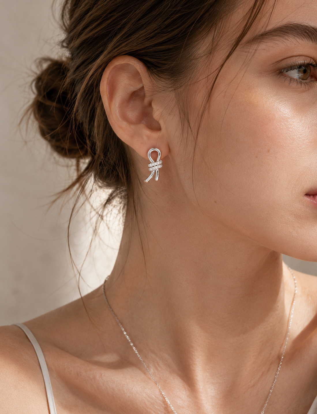 Sterling silver Lucette crystal bow stud earrings worn on a model