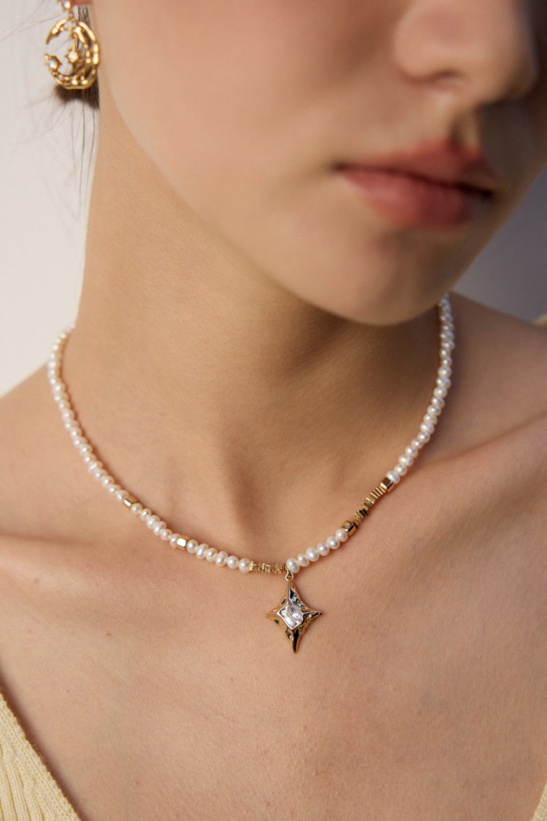 Pearl necklace with a star pendant worn by a person