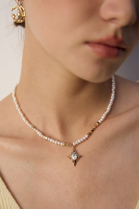 Pearl necklace with a star pendant worn by a person