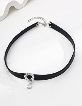 Lumina Heart Drop Choker Necklace in black leather featuring a silver heart-shaped centerpiece and a dangling teardrop zircon, styled on a clean background.