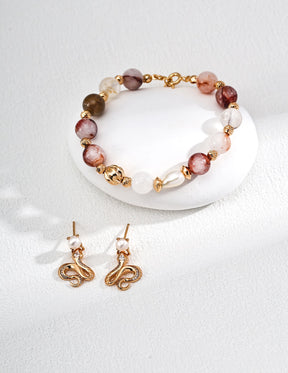Gemstone Bracelet and earrings with gold accents and multicolored beads on a white background