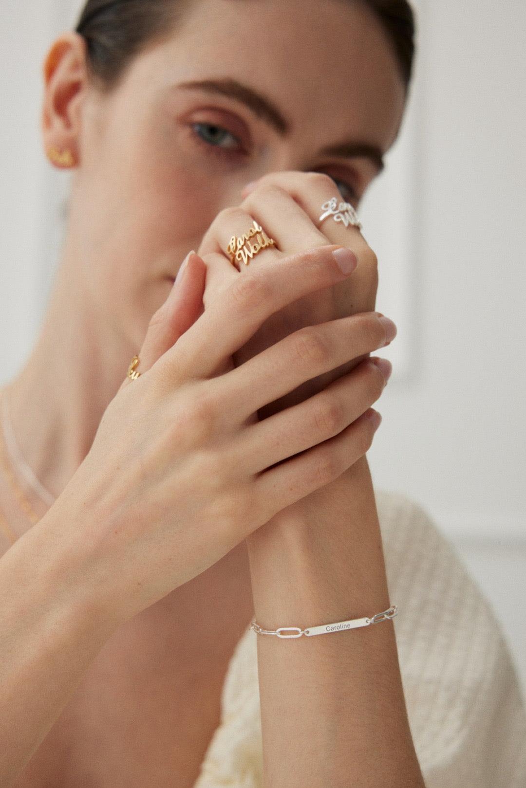 A person wearing a white shirt showcasing a customized bracelet on their wrist.