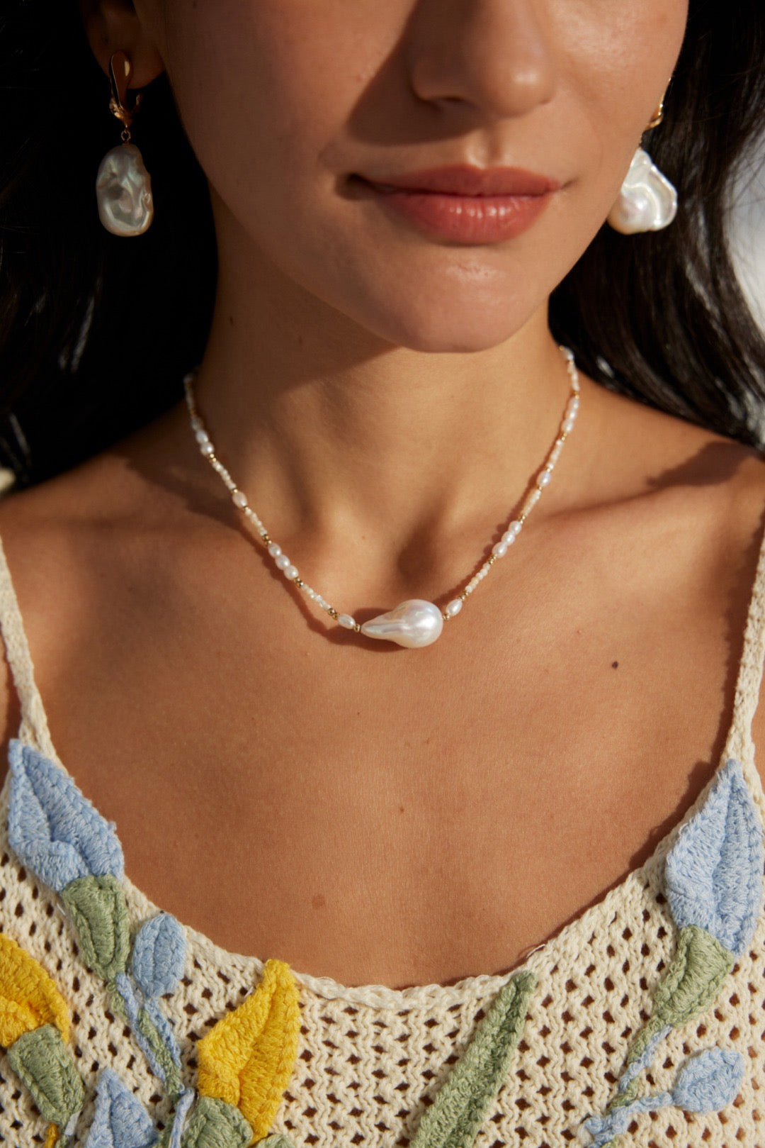 A 2cm baroque pearl pendant & freshwater pearls worn by a woman