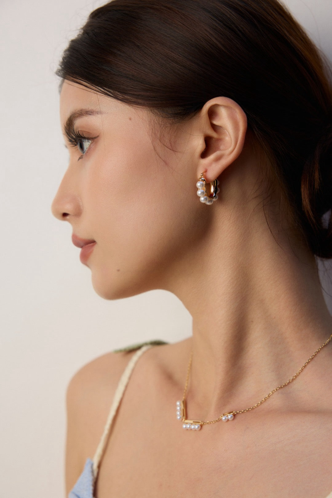 Gold pearl hoop earrings and a necklace with a minimalistic design for women.
