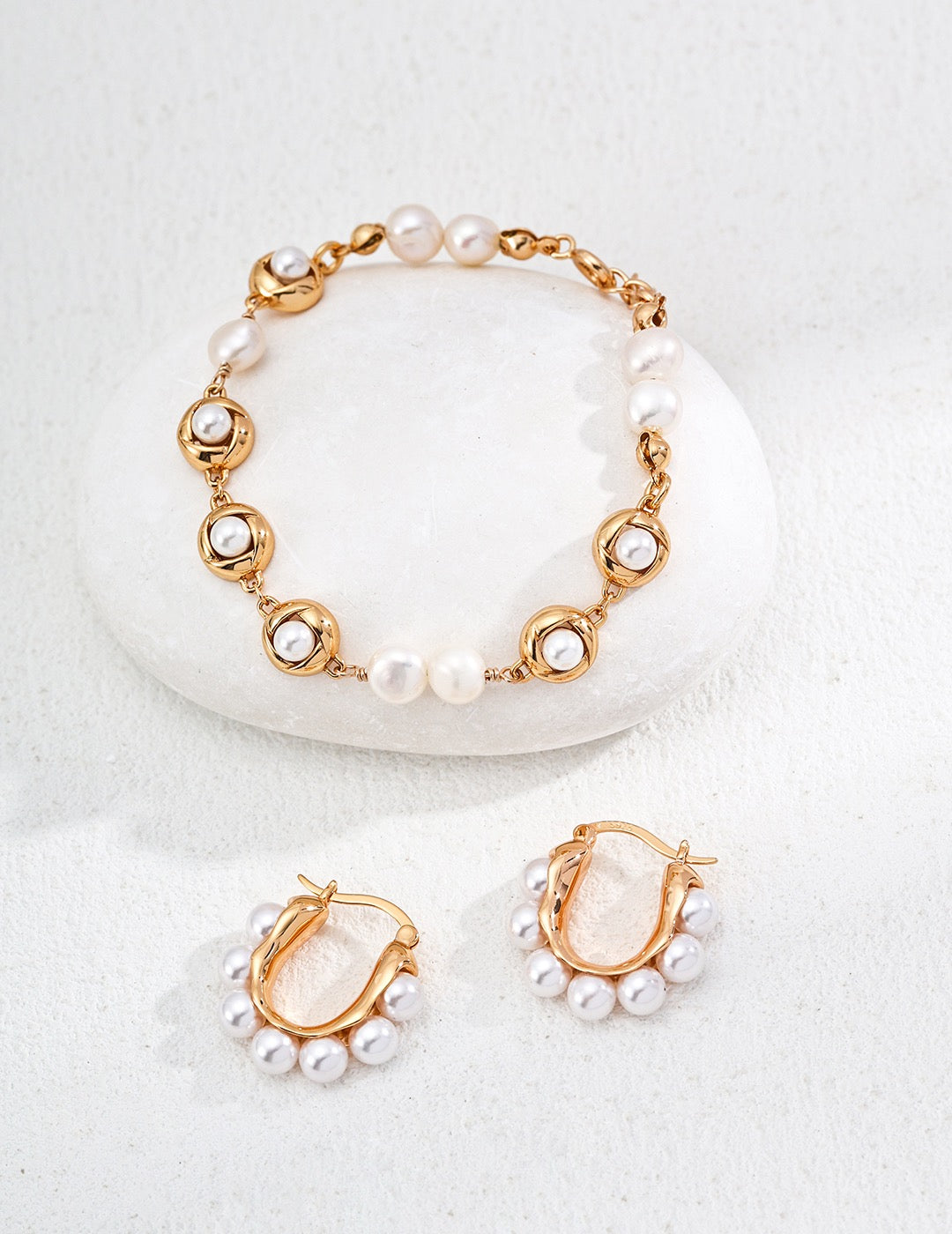 Elegant gold and pearl bracelet and hoop earrings for women.