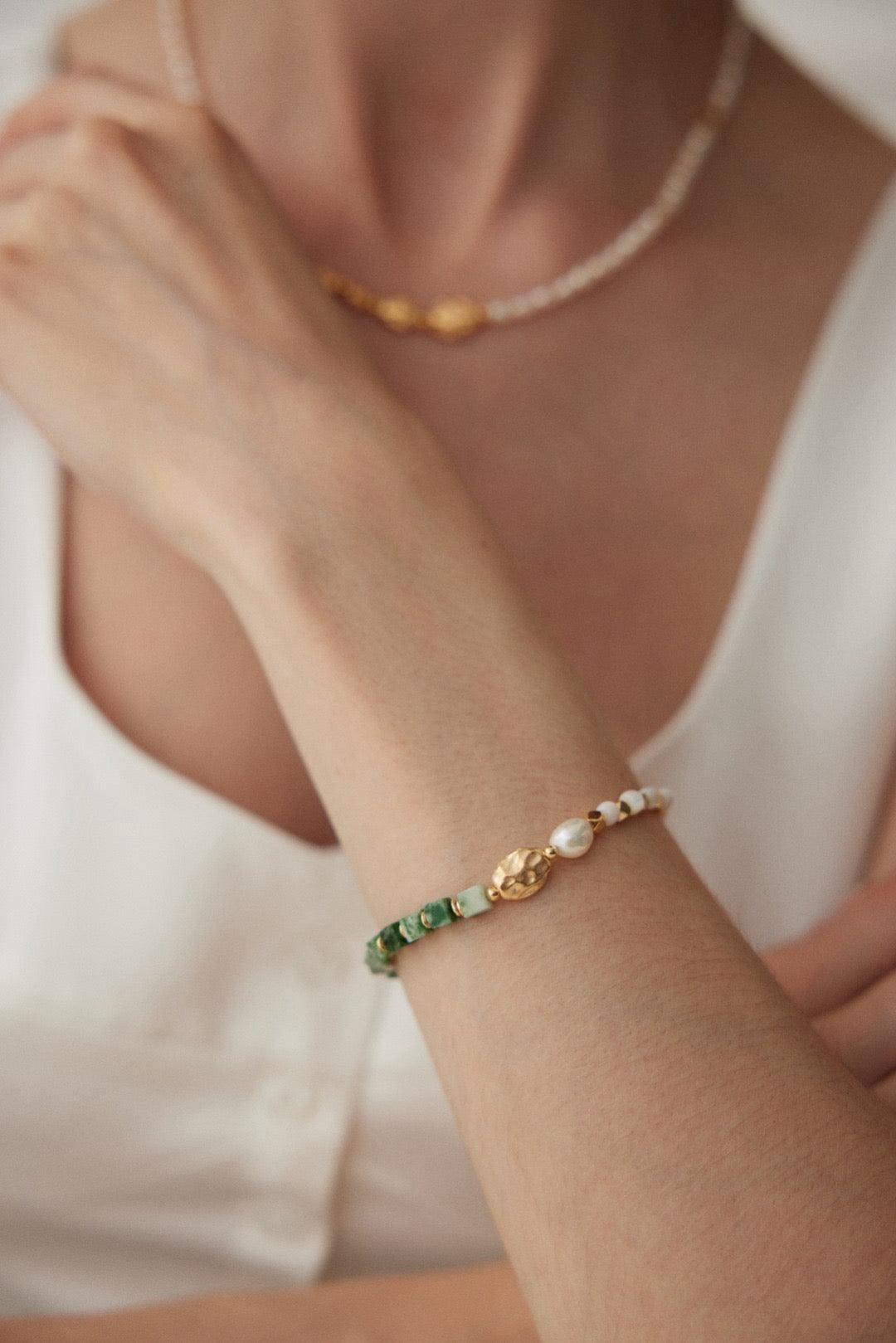 Pearl Shimmer Bracelet featuring Transvaal jade, baroque pearls, and mother-of-pearl with 18K gold vermeil accents wear by a woman. 