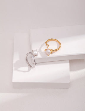 Two stackable open rings, silver and gold, with an 8mm pearl and zircon displayed on the white rocks.