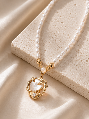 Close-up of pearl strand necklace shell pendant — 18K gold vermeil open cutwork frame with mother-of-pearl shell interior and zircon crystal accent detail