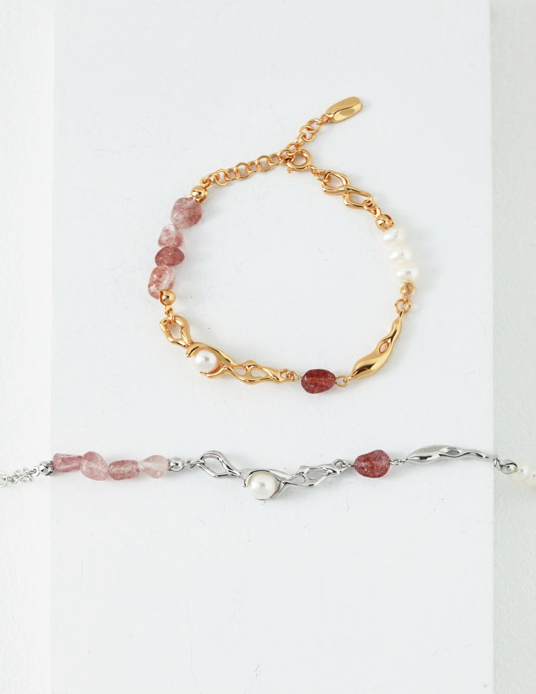 Two bracelets, one with 18K gold vermeil and the other in sterling silver, both featuring asymmetrical rows of pearls and raw strawberry quartz.