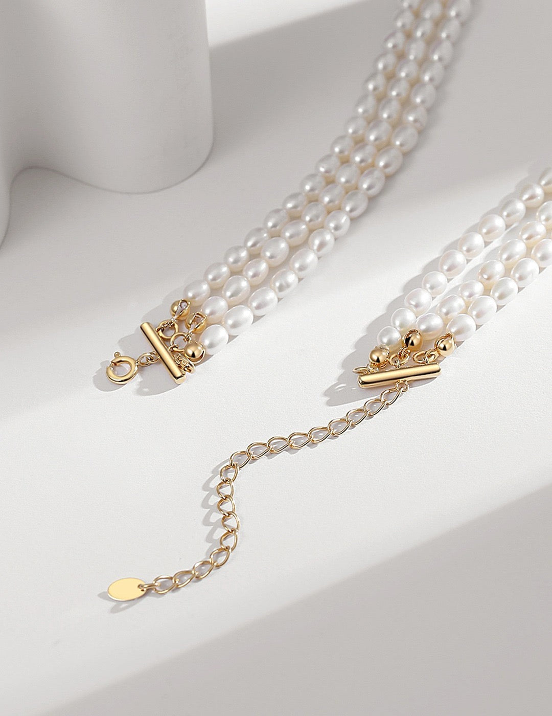 Triple Strand Pearl Choker Necklace with gold clasp on a white background