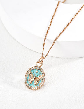 Necklace with a turquoise enamel pendant featuring a butterfly design on a white background