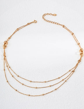 Gold necklace with multiple strands on a white background