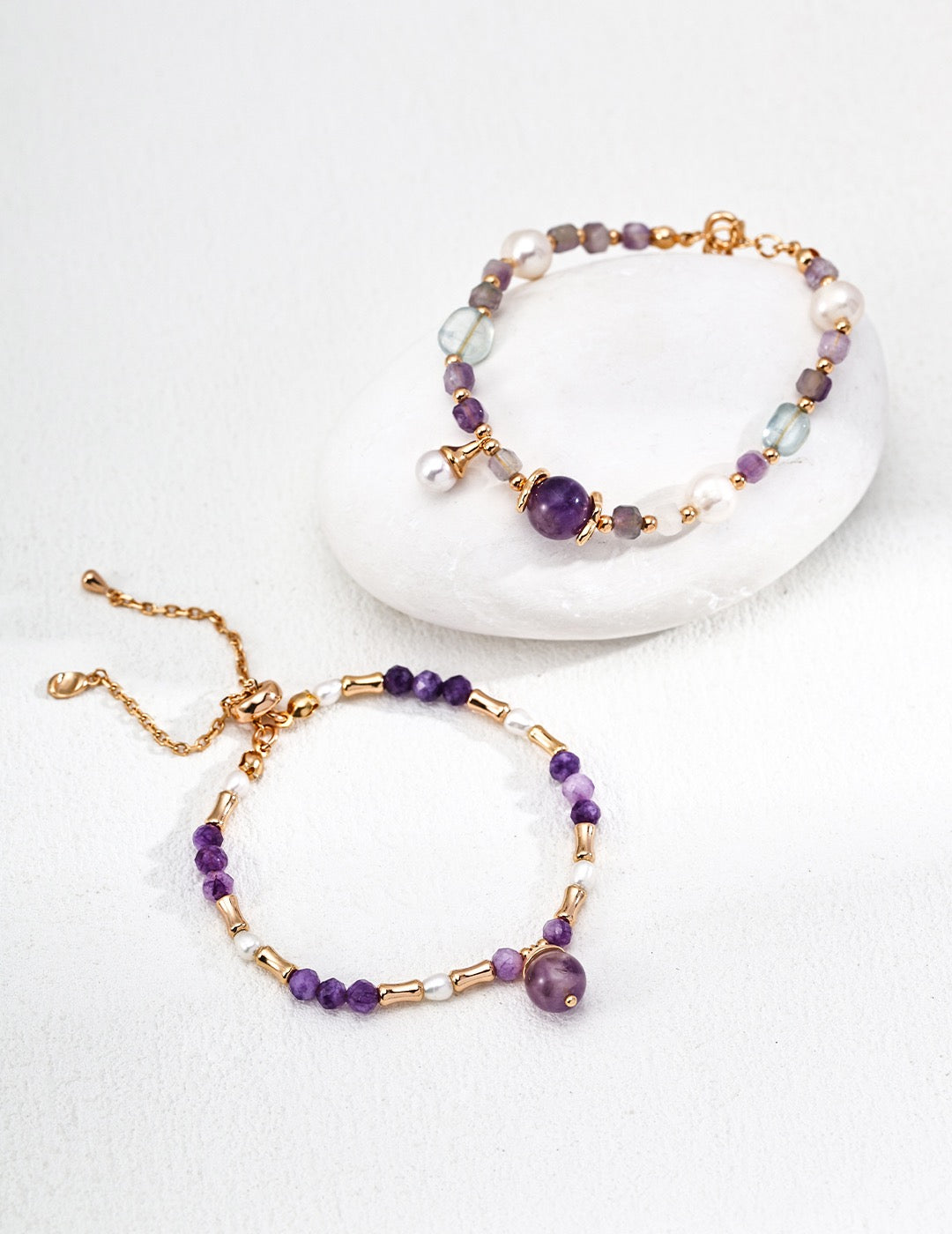 Two beaded bracelets with purple amethysts on a white background
