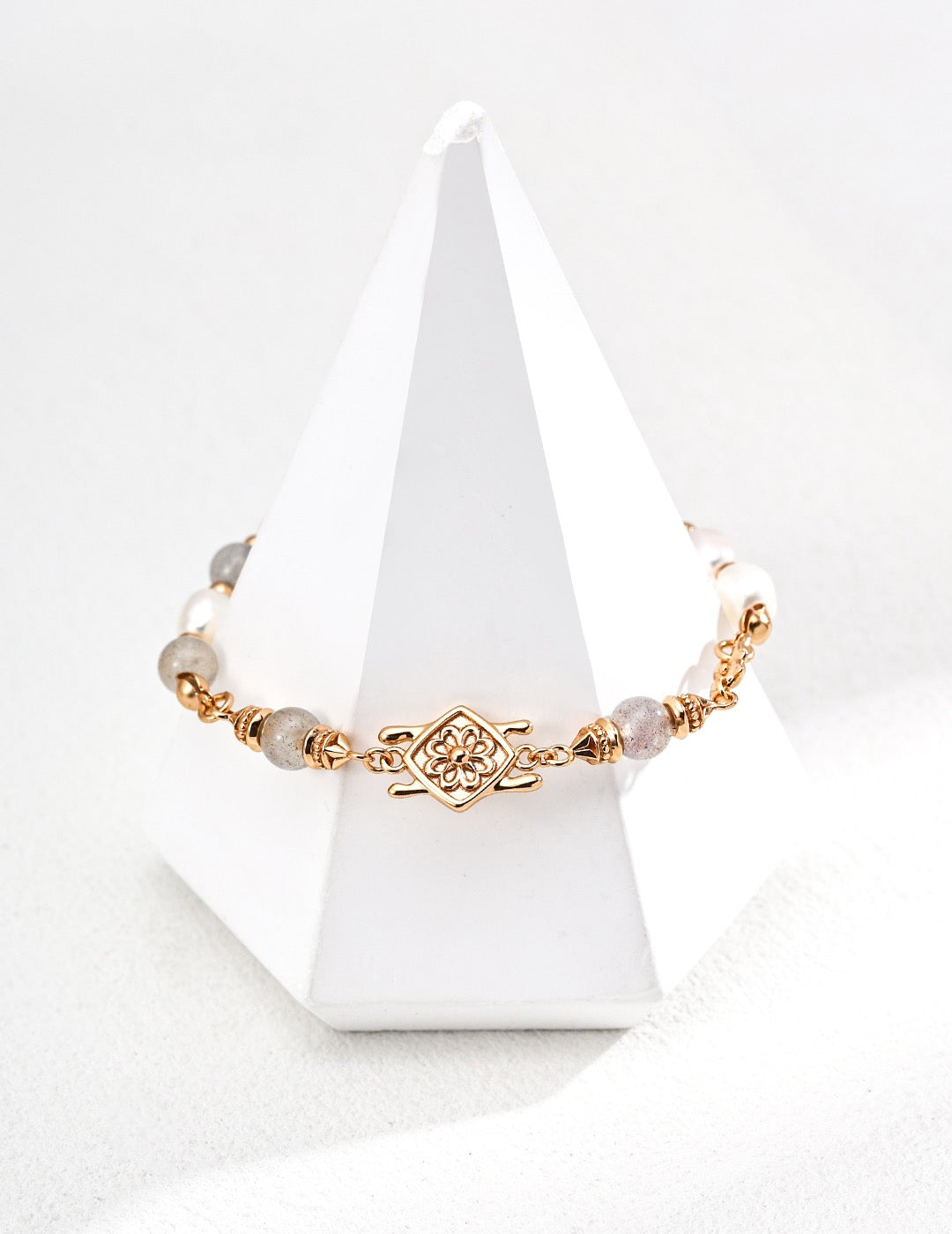 Gold bracelet with Labradorite on a white cone-shaped stand