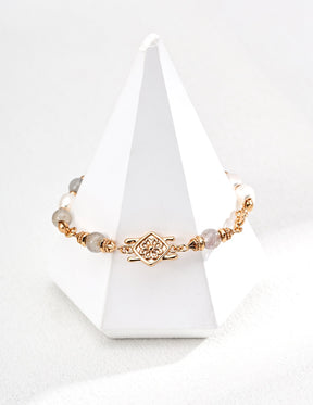 Gold bracelet with Labradorite on a white cone-shaped stand