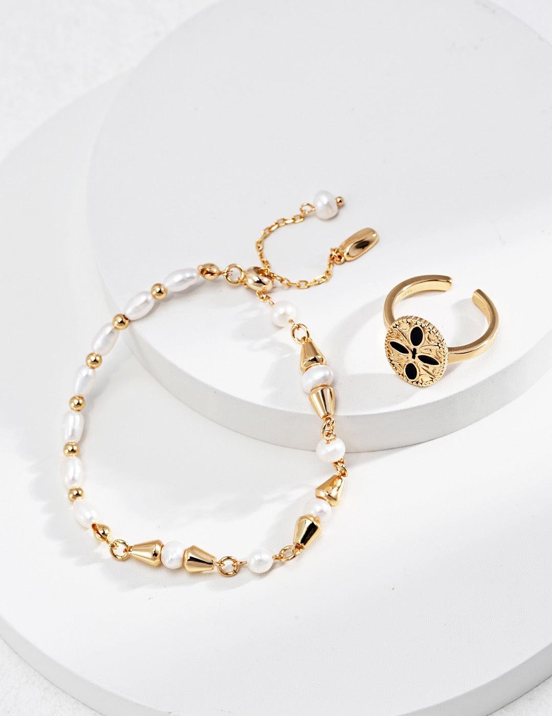 The Vine Pearl Bracelet artfully combines lustrous 4.2-5mm freshwater pearls with sculptural 18K gold vermeil elements in organic teardrop and spherical forms, displayed on the white circular stages.