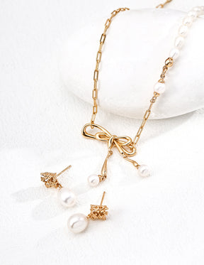 Camellia Freshwater Pearl Drop Earrings in 18K Gold Vermeil and bow pearl pendant necklace displayed on a white background.