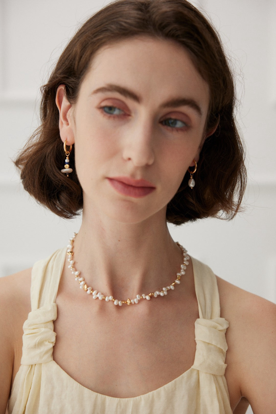 Model wearing the Jasmine freshwater pearl necklace with pearl drop earrings and a cream sleeveless top