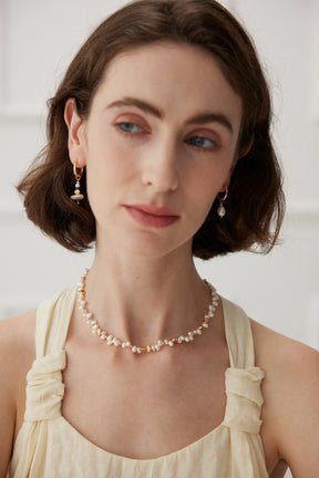 Model wearing the Jasmine freshwater pearl necklace with pearl drop earrings and a cream sleeveless top